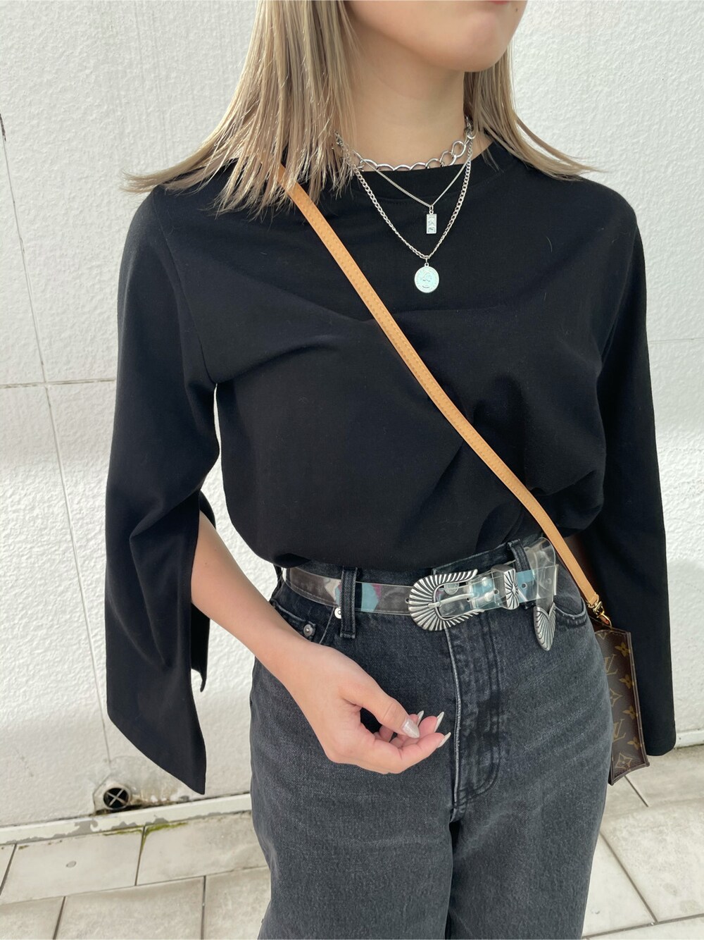 ブラック系のデニムパンツ、ブラック系のパンプス、ブラック系のTシャツ/カットソーを着用したレディースの春コーディネートの3枚目の写真