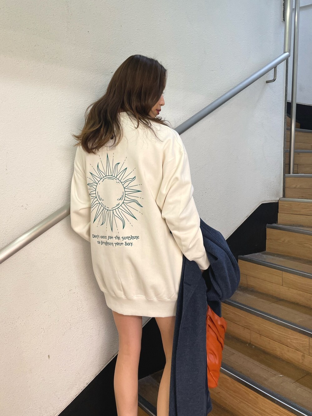 ブラック系のブーツ、ホワイト系のスウェット、ブルー系のその他アウターを着用したレディースの冬コーディネートの6枚目の写真