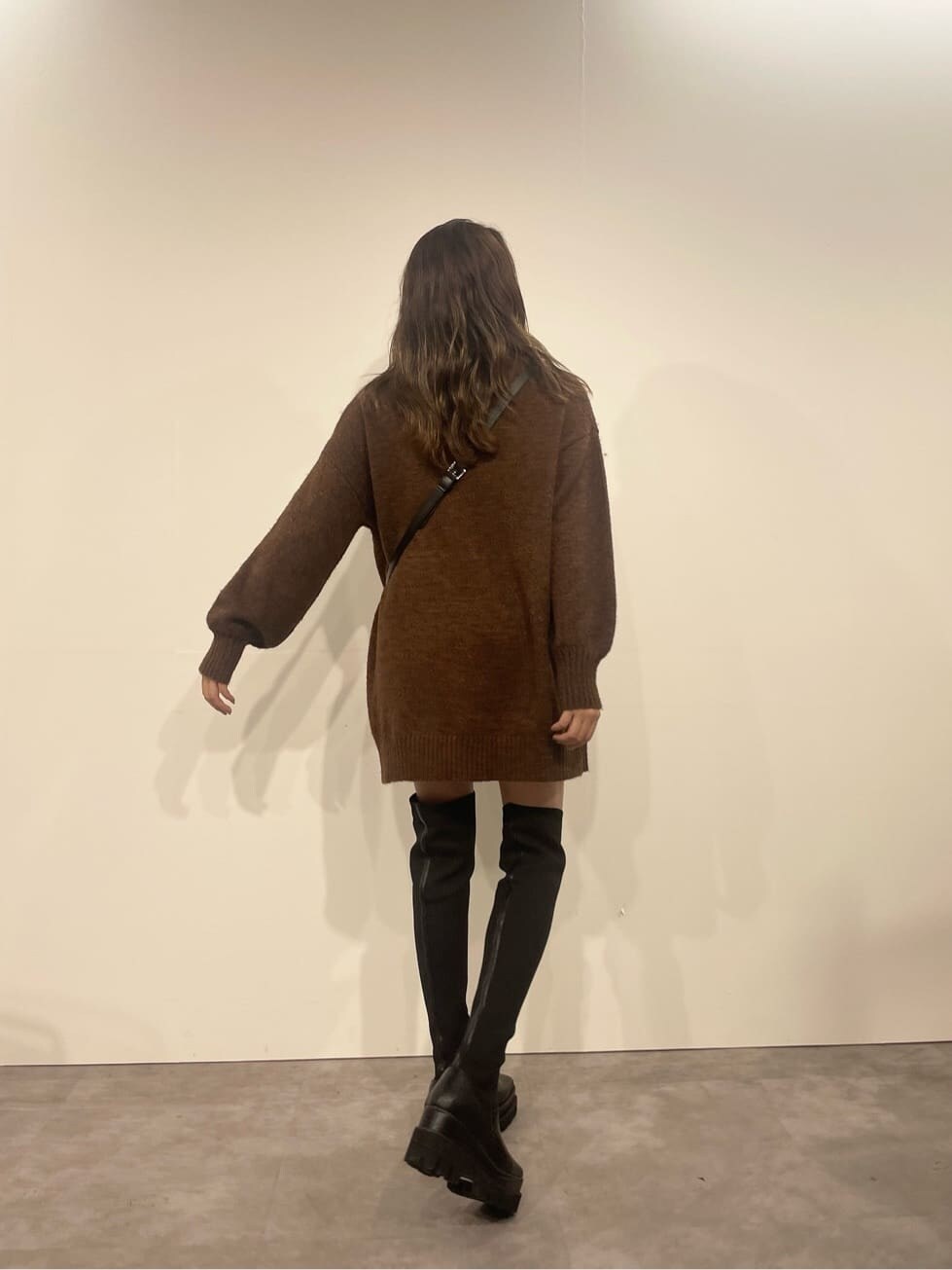 ブラウン系のワンピース、ブラック系のブーツ、ブラック系のショルダーバッグを着用したレディースの秋コーディネートの2枚目の写真