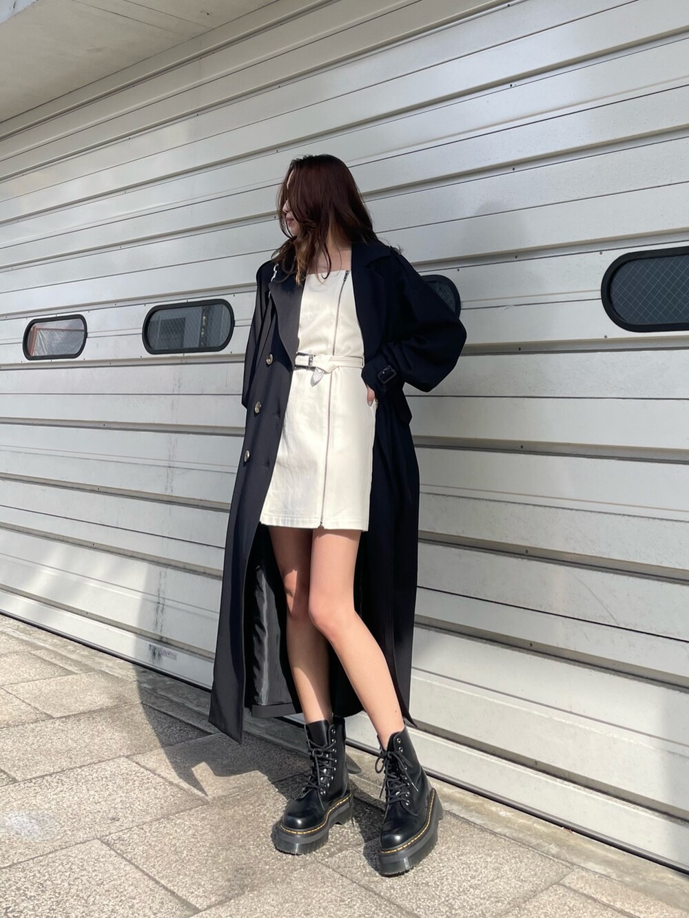 ブラック系のショルダーバッグ、ブラック系のトレンチコート、ホワイト系のワンピースを着用したレディースの冬コーディネートの2枚目の写真