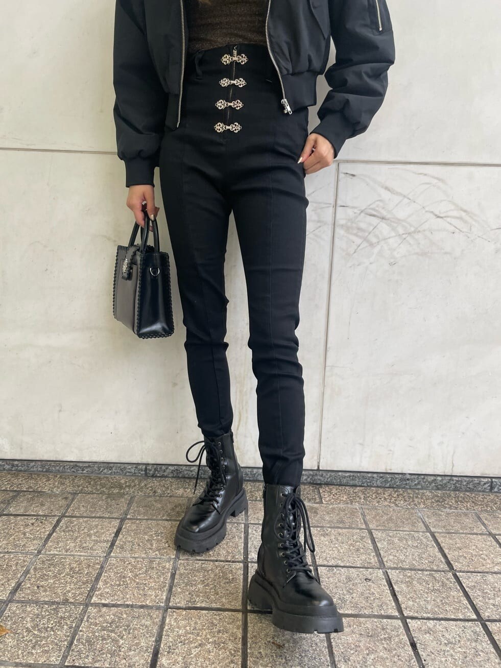 ブラック系のブーツ、ブラック系のデニムパンツ、ブラック系のショルダーバッグを着用したレディースの秋コーディネートの9枚目の写真