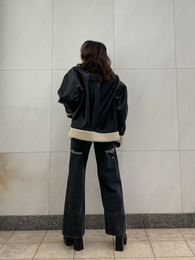 ブラック系のデニムパンツ、ブラック系のブルゾン、ブラック系のニット/セーターを着用したレディースの秋コーディネートの5枚目の写真