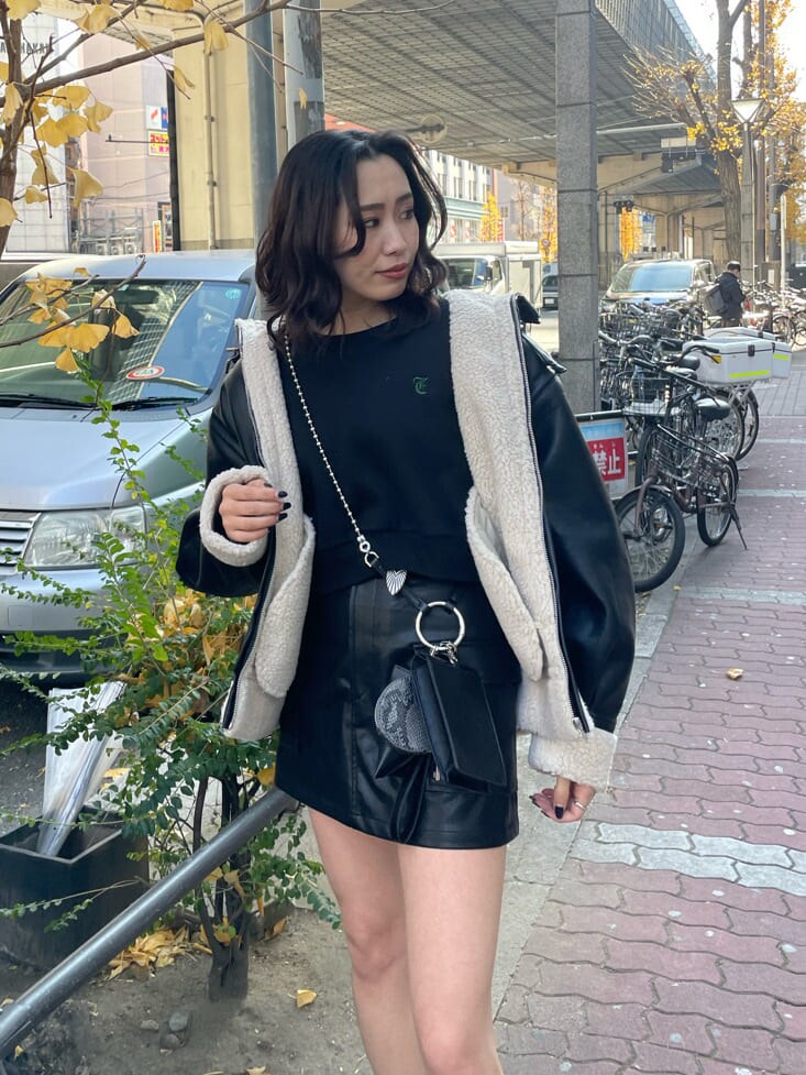 ブラック系のブーツ、ブラック系のハンドバッグ、ブラック系のブルゾンを着用したレディースの冬コーディネートの3枚目の写真