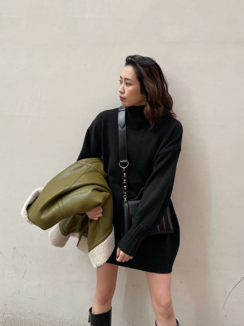 グリーン系のブルゾン、ブラック系のショルダーバッグ、ブラック系のワンピースを着用したレディースの冬コーディネートの3枚目の写真