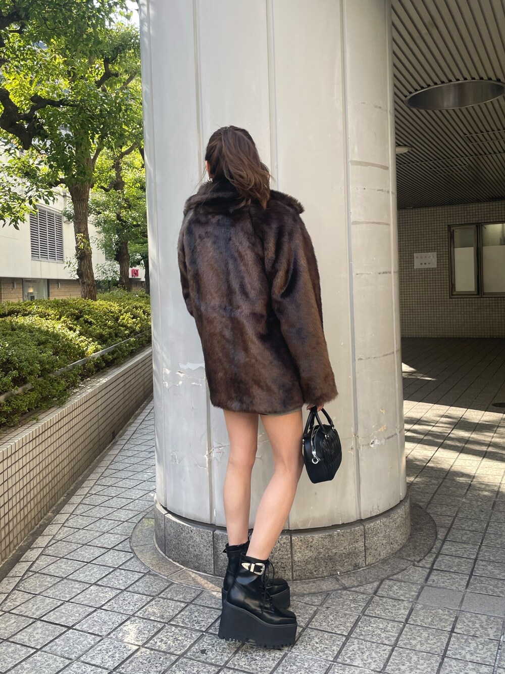 グレー系のスウェット、ブラック系のショルダーバッグ、ブラック系のブーツを着用したレディースの冬コーディネートの2枚目の写真