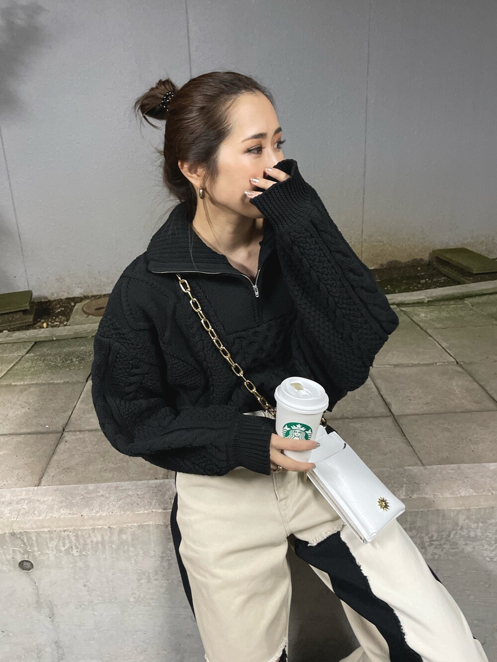 ブラック系のブーツ、ホワイト系のショルダーバッグ、ブラック系のニット/セーターを着用したレディースの冬コーディネートの4枚目の写真