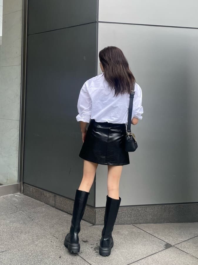 ブラック系のブーツ、ホワイト系のシャツ/ブラウス、ブラック系のスカートを着用したレディースの夏コーディネートの2枚目の写真