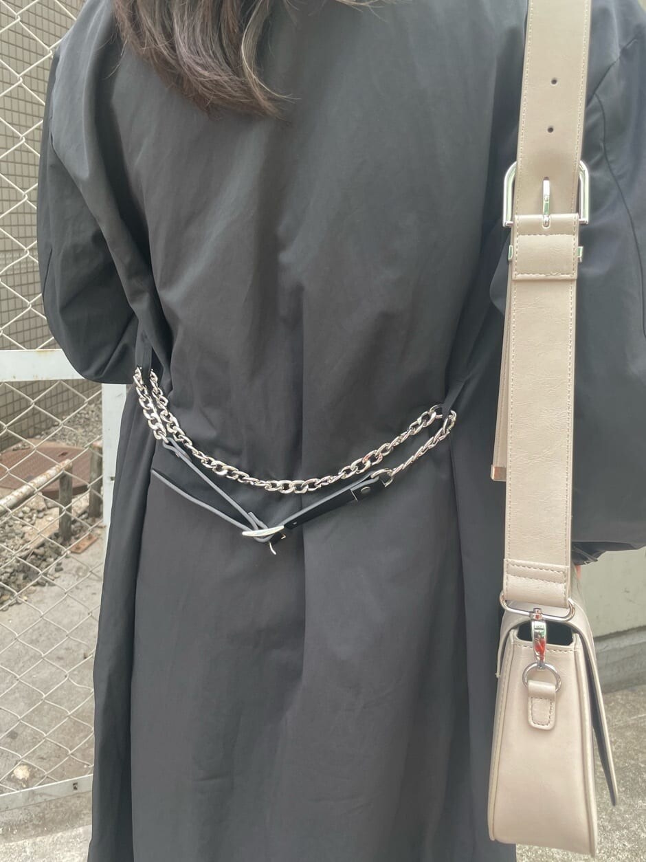 ブラック系のブーツ、ブラック系のトレンチコート、ブラック系のワンピースを着用したレディースの春コーディネートの9枚目の写真