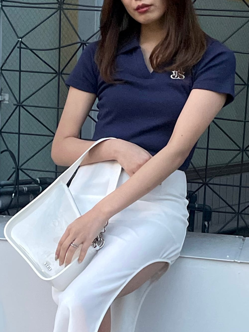 ホワイト系のブーツ、ホワイト系のスカート、ホワイト系のハンドバッグを着用したレディースの春コーディネートの3枚目の写真