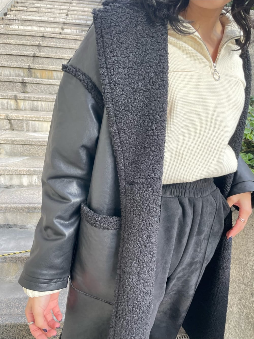 ブラック系のブーツ、ホワイト系のスウェット、ブラック系のその他アウターを着用したレディースの冬コーディネートの8枚目の写真