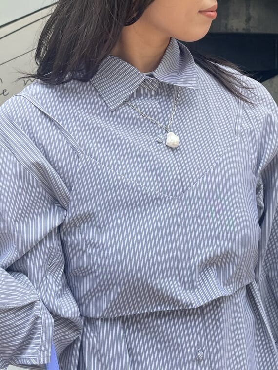 ブラック系のブーツ、ブラック系のワンピース、パープル系のショルダーバッグを着用したレディースの春コーディネートの6枚目の写真