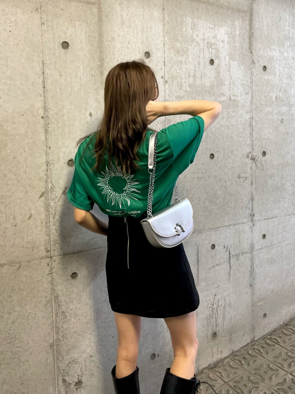 グリーン系のTシャツ/カットソー、ブラック系のスカート、ブラック系のブーツを着用したレディースの夏コーディネートの6枚目の写真