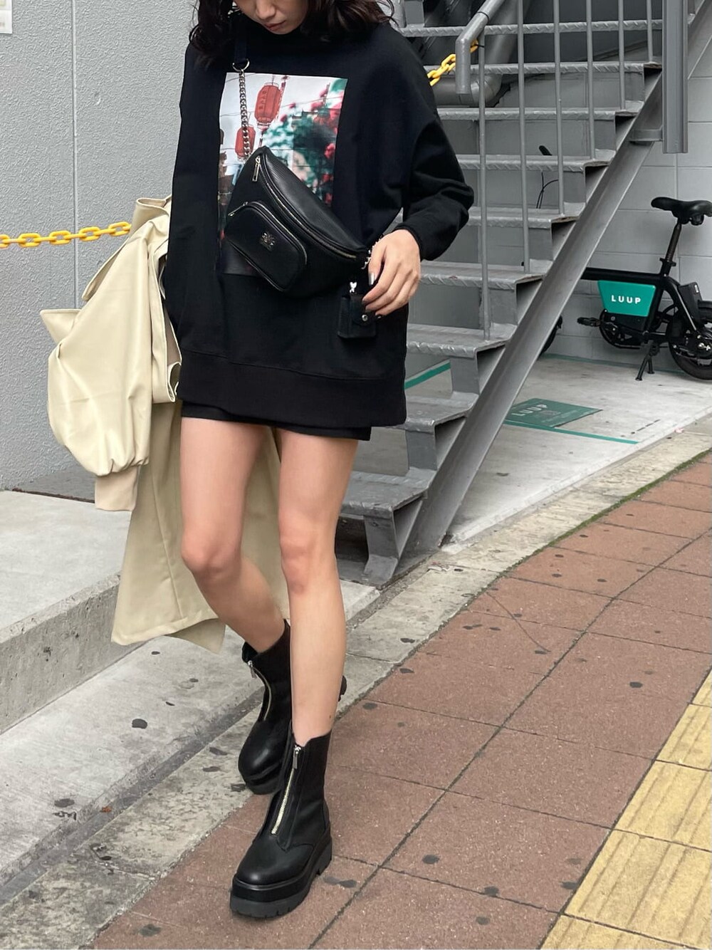 ブラック系のボディバッグ/ウエストポーチ、ブラック系のTシャツ/カットソー、ブラック系のブーツを着用したレディースの冬コーディネートの3枚目の写真