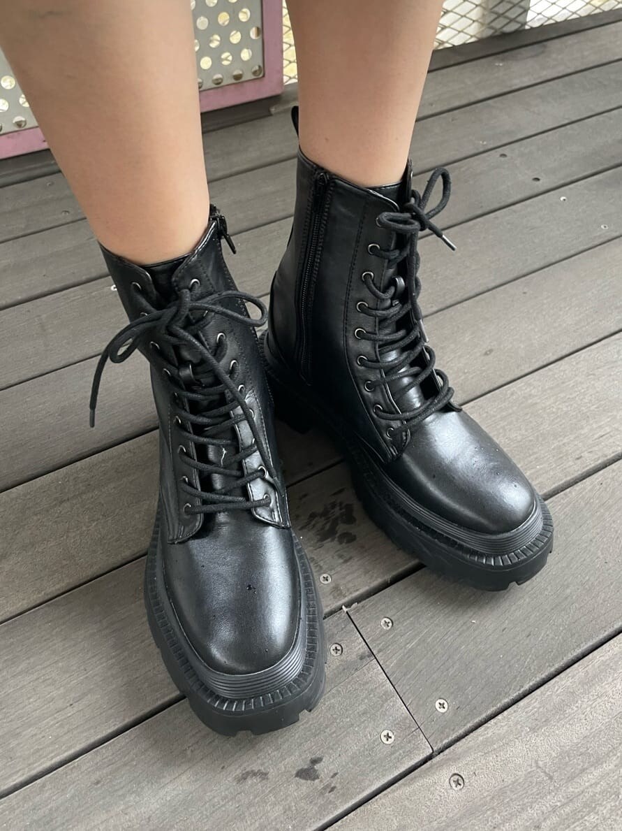 ブラック系のブーツ、ブラック系のワンピース、ホワイト系のショルダーバッグを着用したレディースの春コーディネートの8枚目の写真