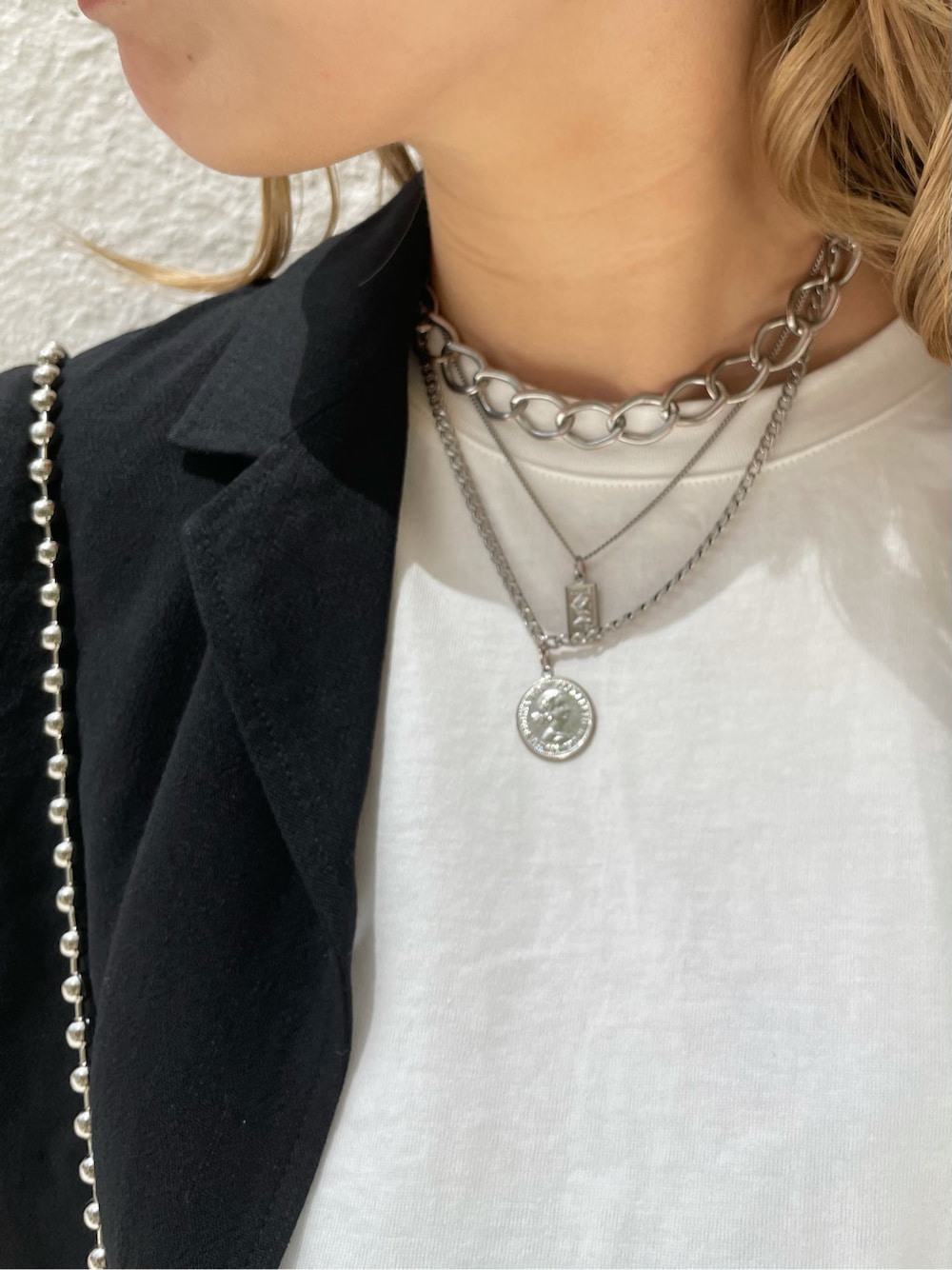 ブラック系のスカート、ブラック系のサンダル、シルバー系のネックレスを着用したレディースの春コーディネートの6枚目の写真