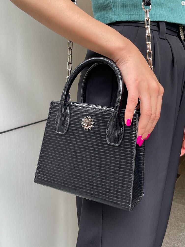 ブラック系のその他パンツ、グリーン系のTシャツ/カットソー、ブラック系のブーツを着用したレディースの春コーディネートの6枚目の写真