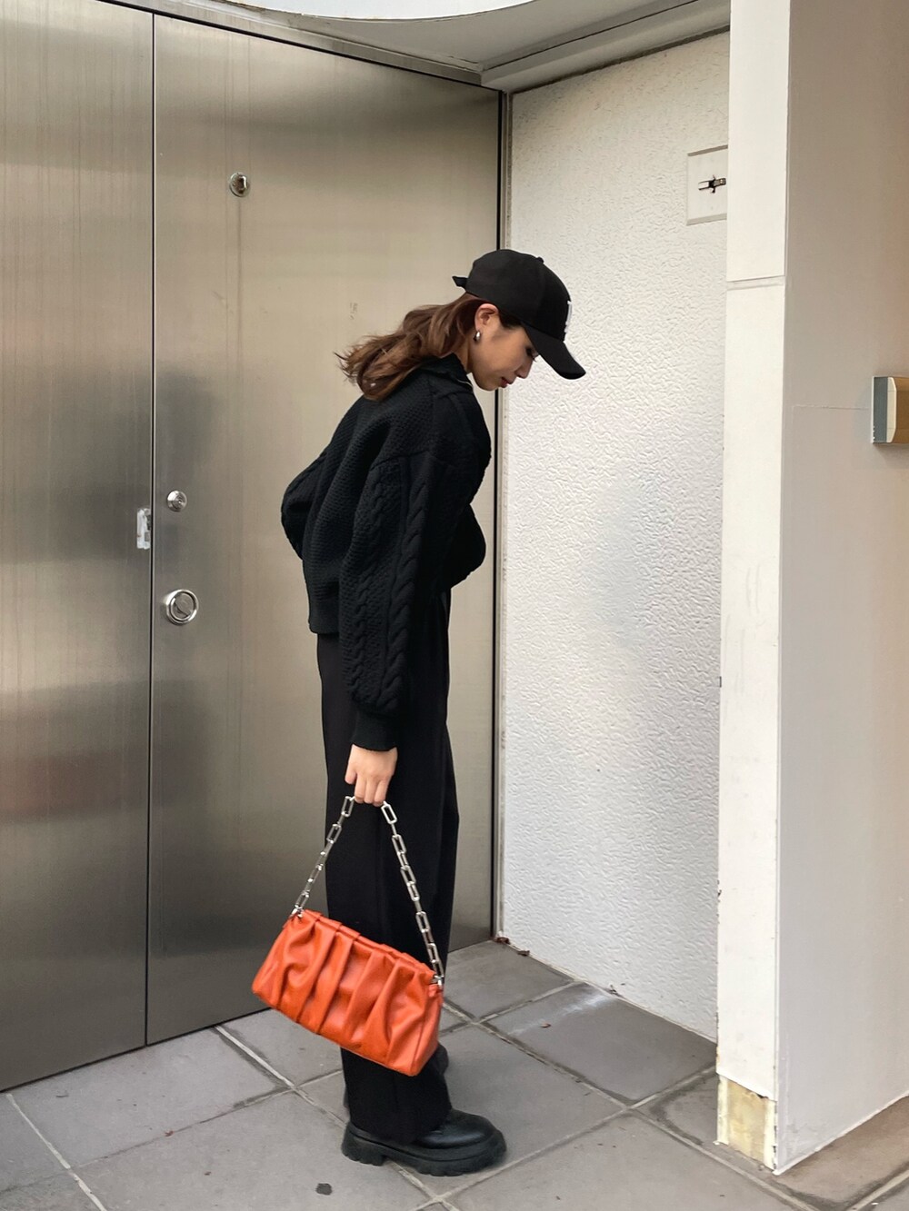 ブラック系のニット/セーター、ブラック系のスラックス、ブラック系のブーツを着用したレディースの冬コーディネートの4枚目の写真