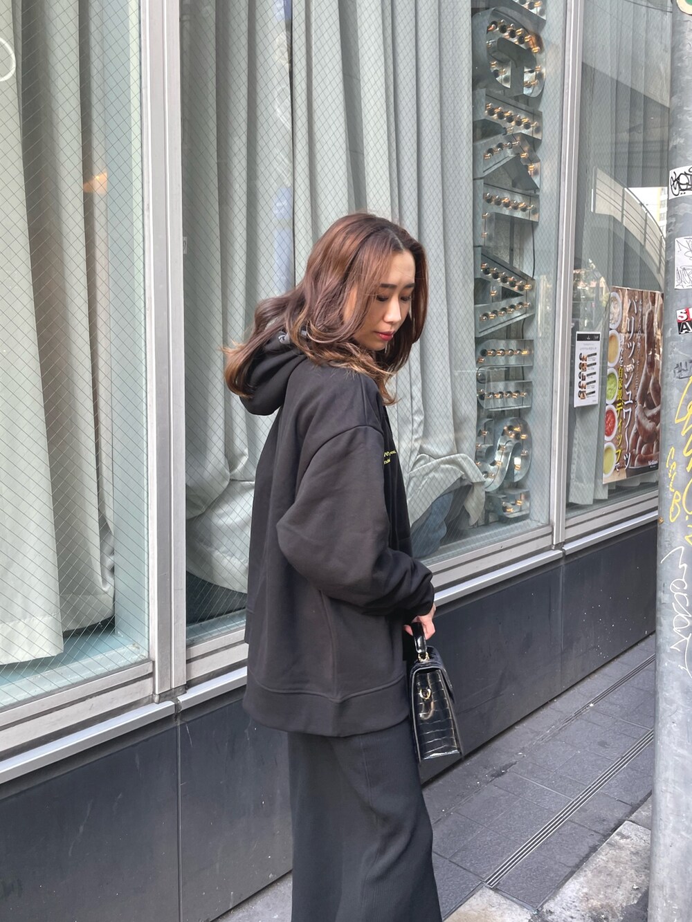 ブラック系のパーカー、ブラック系のショルダーバッグ、ブラック系のワンピースを着用したレディースの冬コーディネートの3枚目の写真