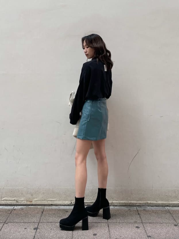 ホワイト系のブルゾン、ブルー系のスカート、ブラック系のTシャツ/カットソーを着用したレディースの冬コーディネートの4枚目の写真