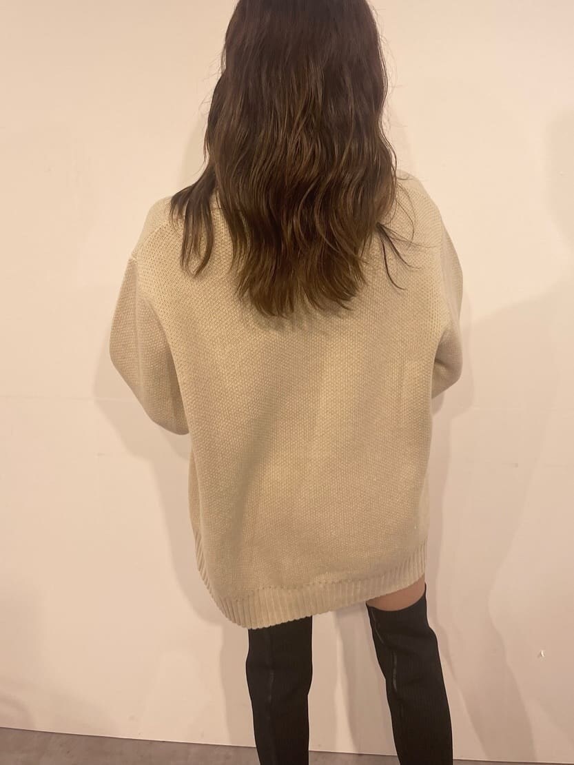 ブラック系のショルダーバッグ、ホワイト系のニット/セーター、ブラック系のブーツを着用したレディースの秋コーディネートの4枚目の写真