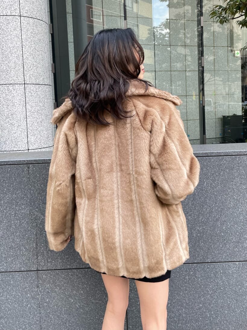 ベージュ系のその他アウター、ブラック系のハンドバッグ、ブラック系のブーツを着用したレディースの冬コーディネートの7枚目の写真