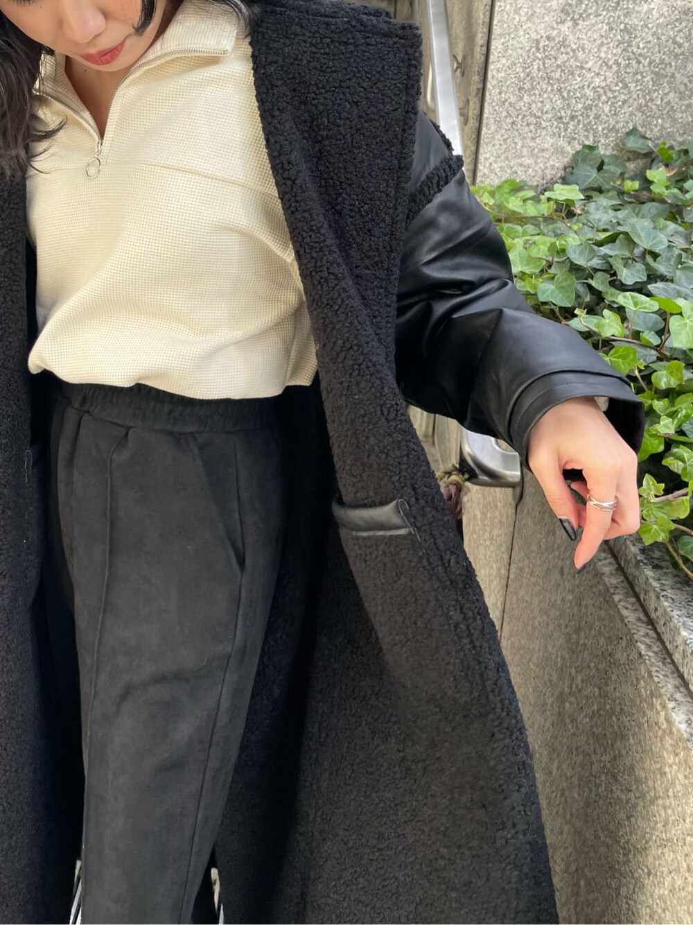 ブラック系のブーツ、ホワイト系のスウェット、ブラック系のその他アウターを着用したレディースの冬コーディネートの7枚目の写真