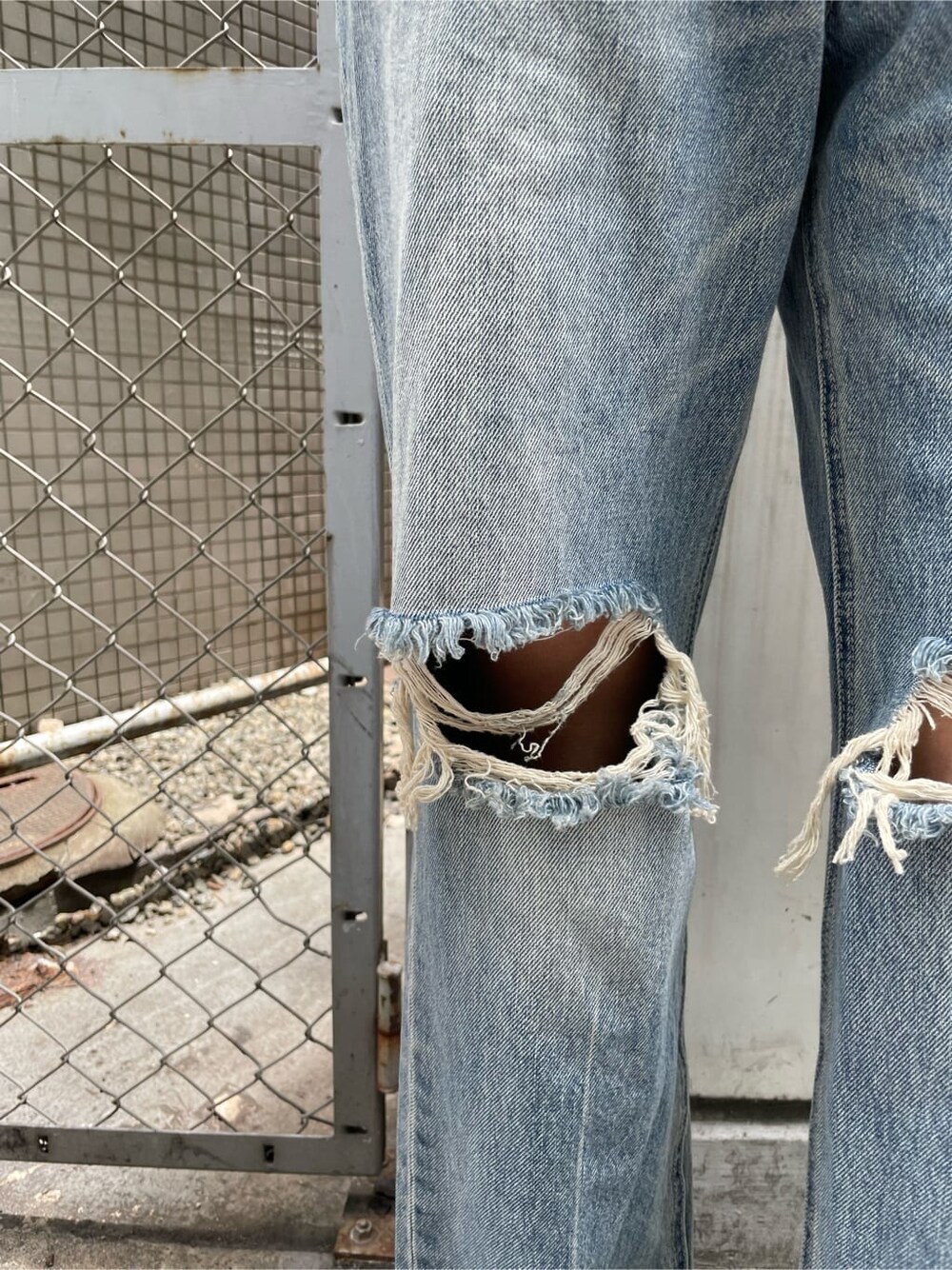 ブラック系のサンダル、ブルー系のデニムパンツ、オレンジ系のTシャツ/カットソーを着用したレディースの夏コーディネートの6枚目の写真