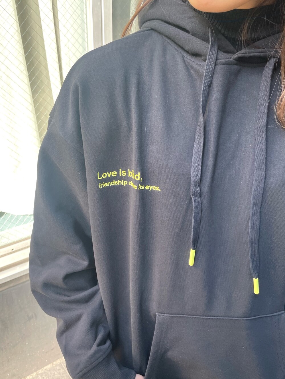 ブラック系のパーカー、ブラック系のショルダーバッグ、ブラック系のワンピースを着用したレディースの冬コーディネートの5枚目の写真