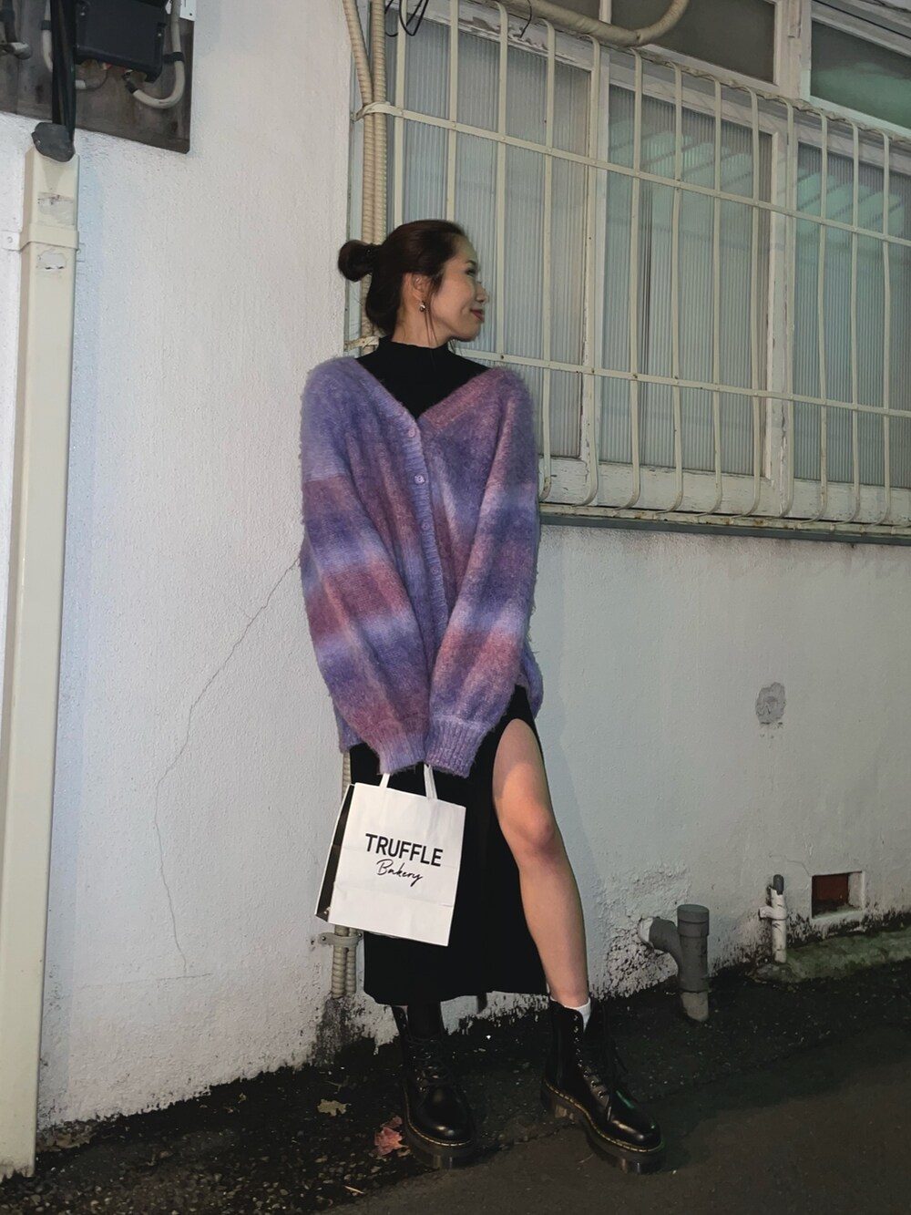 パープル系のカーディガン/ボレロ、ブラック系のワンピース、ブラック系のブーツを着用したレディースの冬コーディネートの3枚目の写真