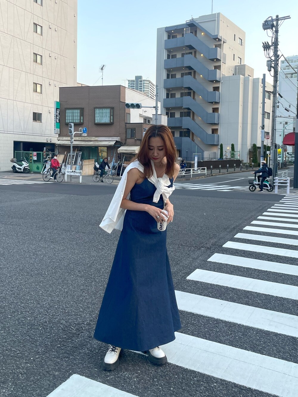 ホワイト系のシャツ/ブラウス、ブルー系のワンピース、ホワイト系のブーツを着用したレディースの春コーディネートの2枚目の写真