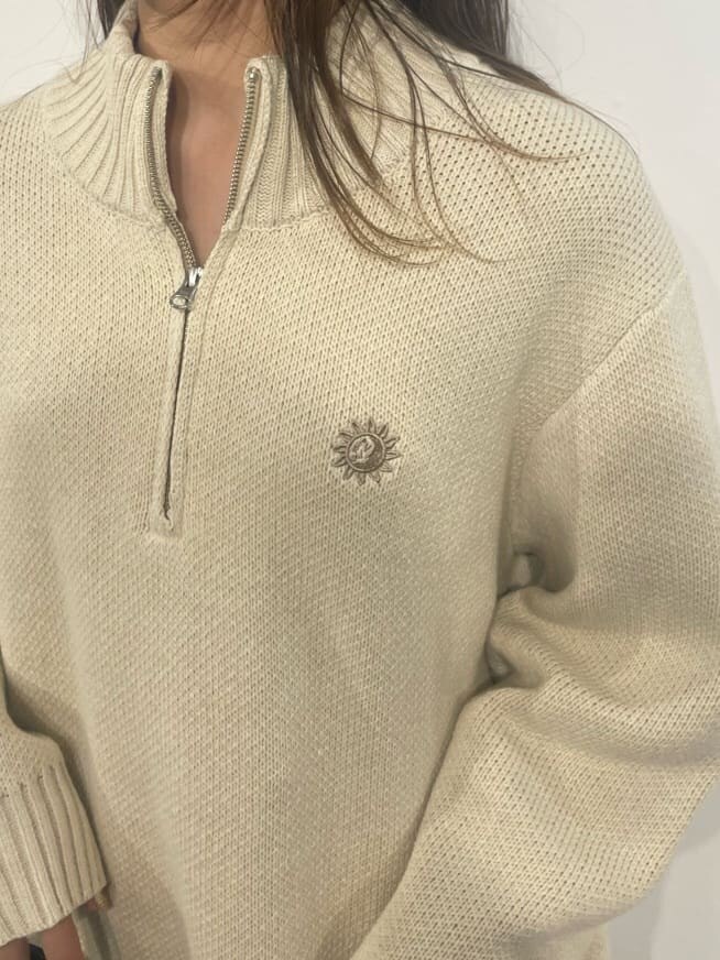 ブラック系のショルダーバッグ、ホワイト系のニット/セーター、ブラック系のブーツを着用したレディースの秋コーディネートの5枚目の写真