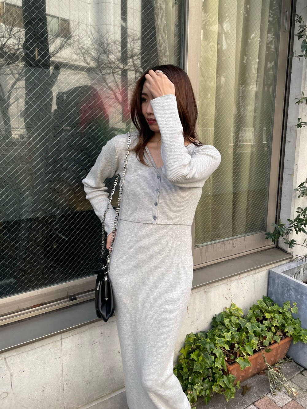 ブラック系のテーラードジャケット、グレー系のワンピース、ブラック系のショルダーバッグを着用したレディースの冬コーディネートの3枚目の写真