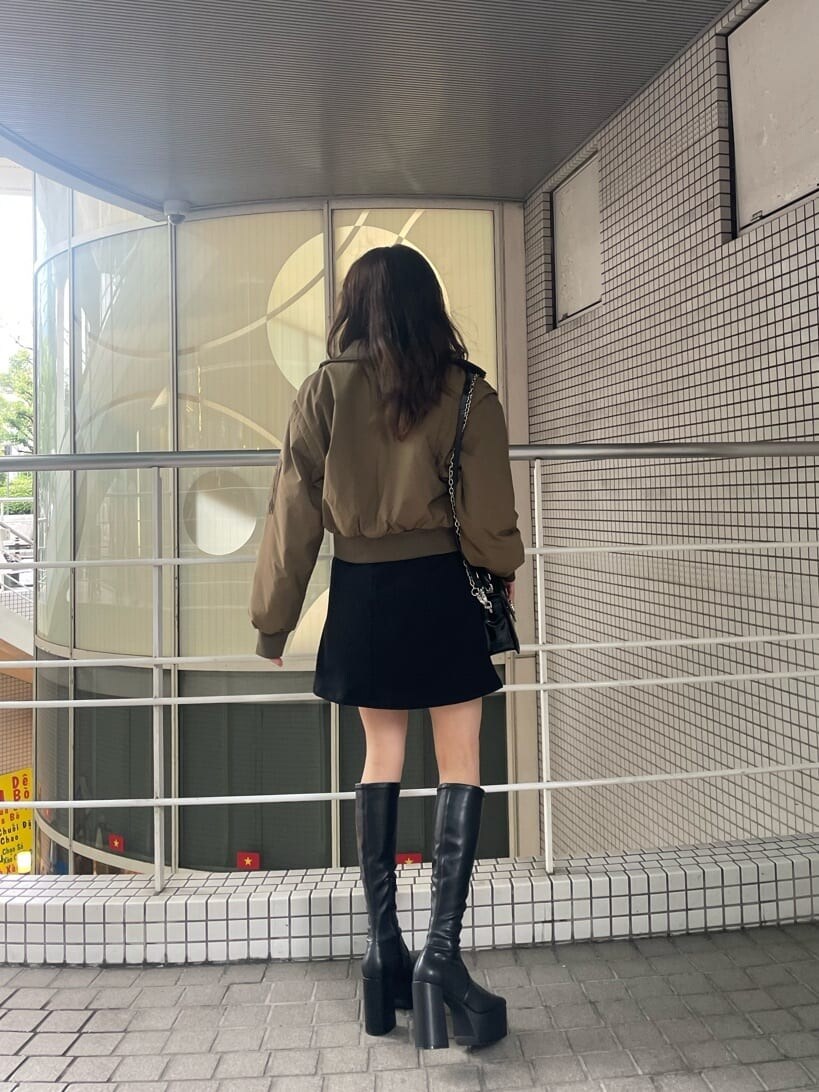 グリーン系のMA-1、ブラック系のハンドバッグ、ブラック系のワンピースを着用したレディースの秋コーディネートの2枚目の写真