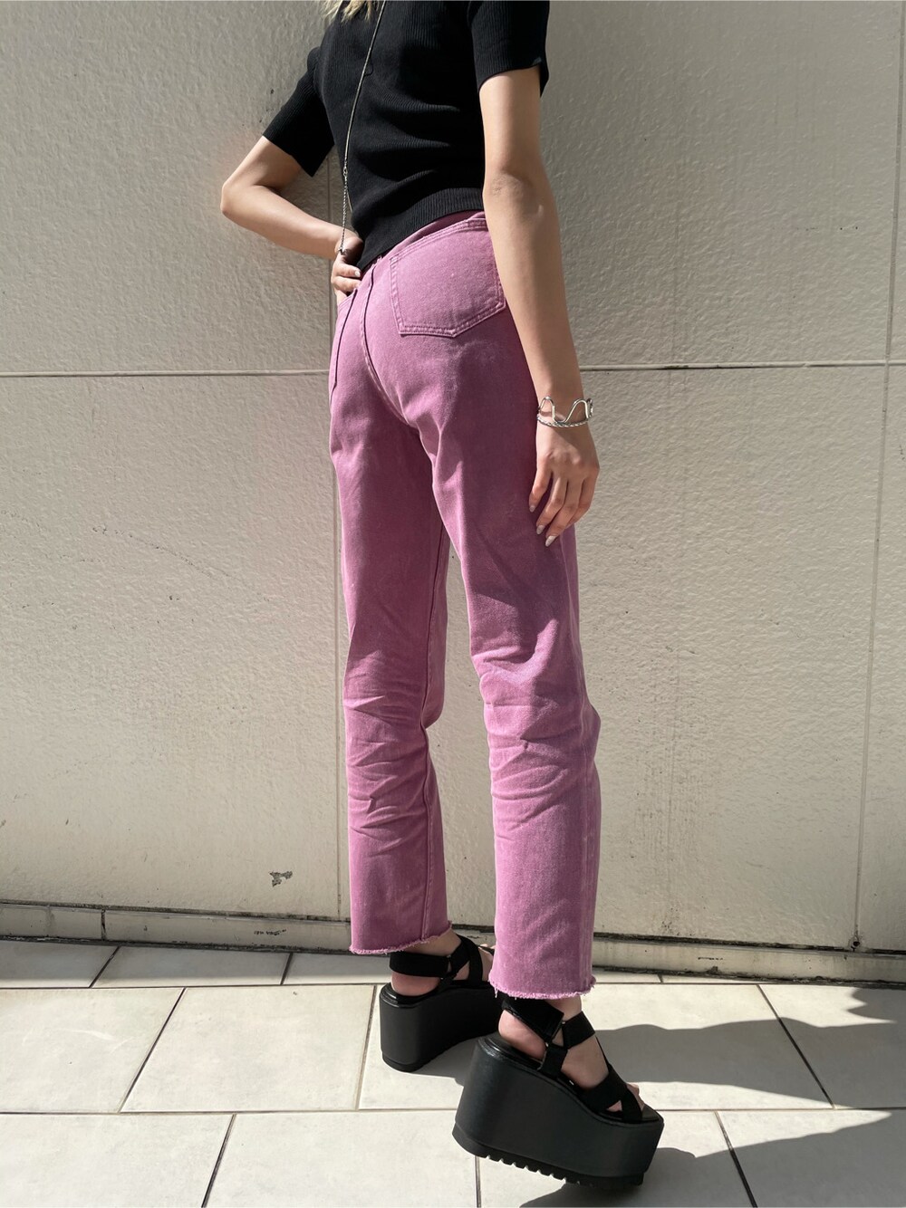 ブラック系のサンダル、パープル系のデニムパンツ、ブラック系のTシャツ/カットソーを着用したレディースの春コーディネートの2枚目の写真