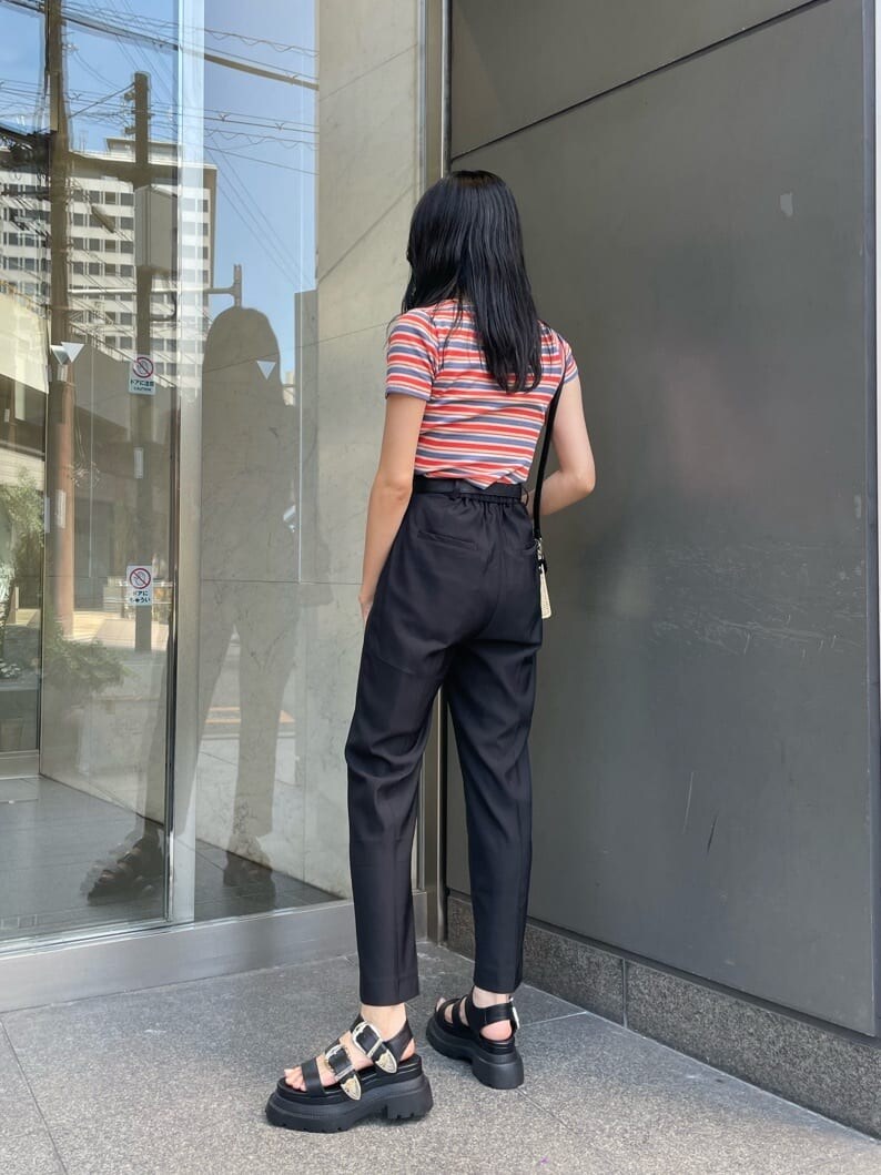 ブラック系のその他パンツ、オレンジ系のTシャツ/カットソー、ブラック系のショルダーバッグを着用したレディースの夏コーディネートの2枚目の写真