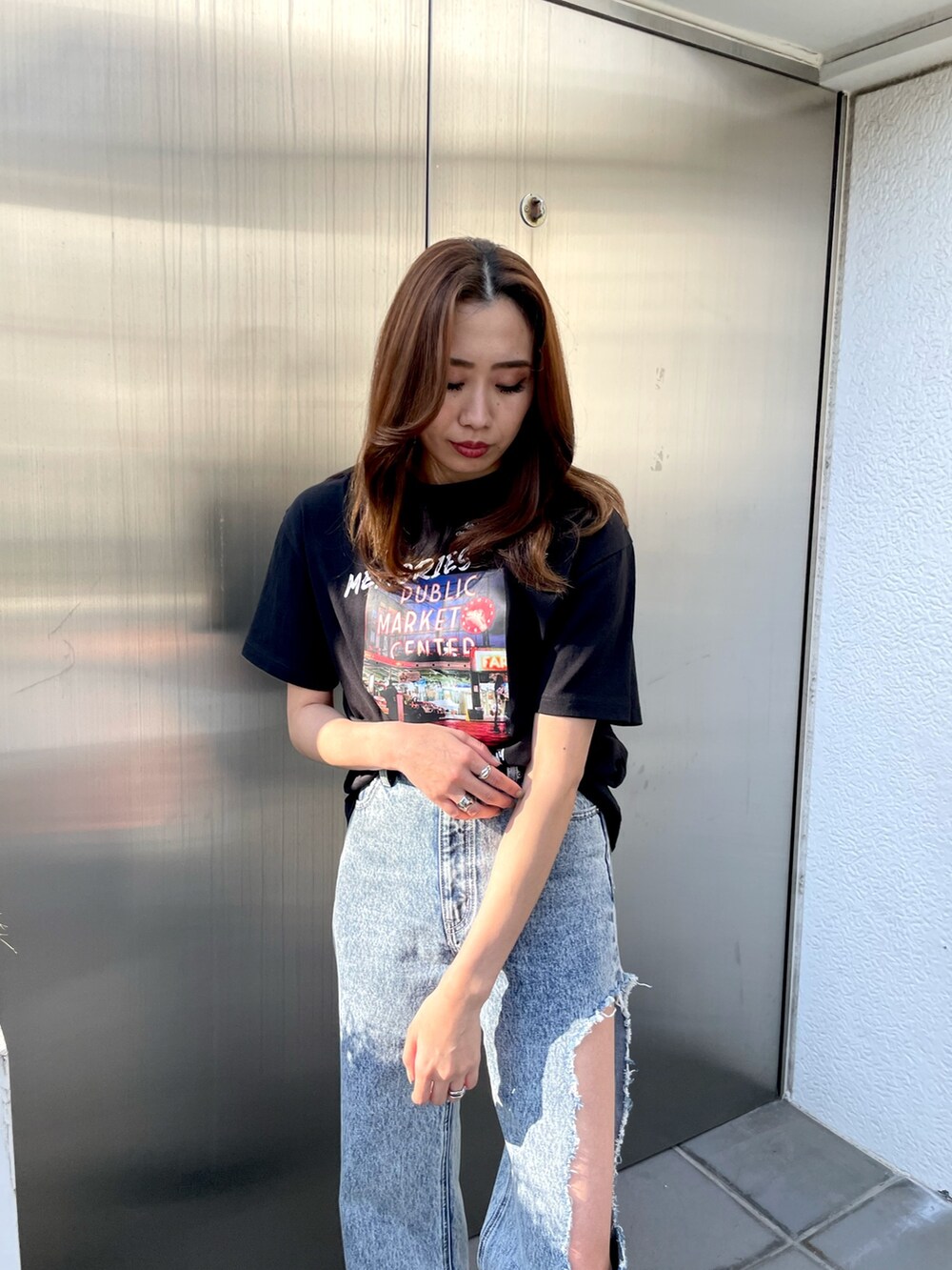 ブラック系のTシャツ/カットソー、ブルー系のデニムパンツ、ブラック系のブーツを着用したレディースの春コーディネートの4枚目の写真