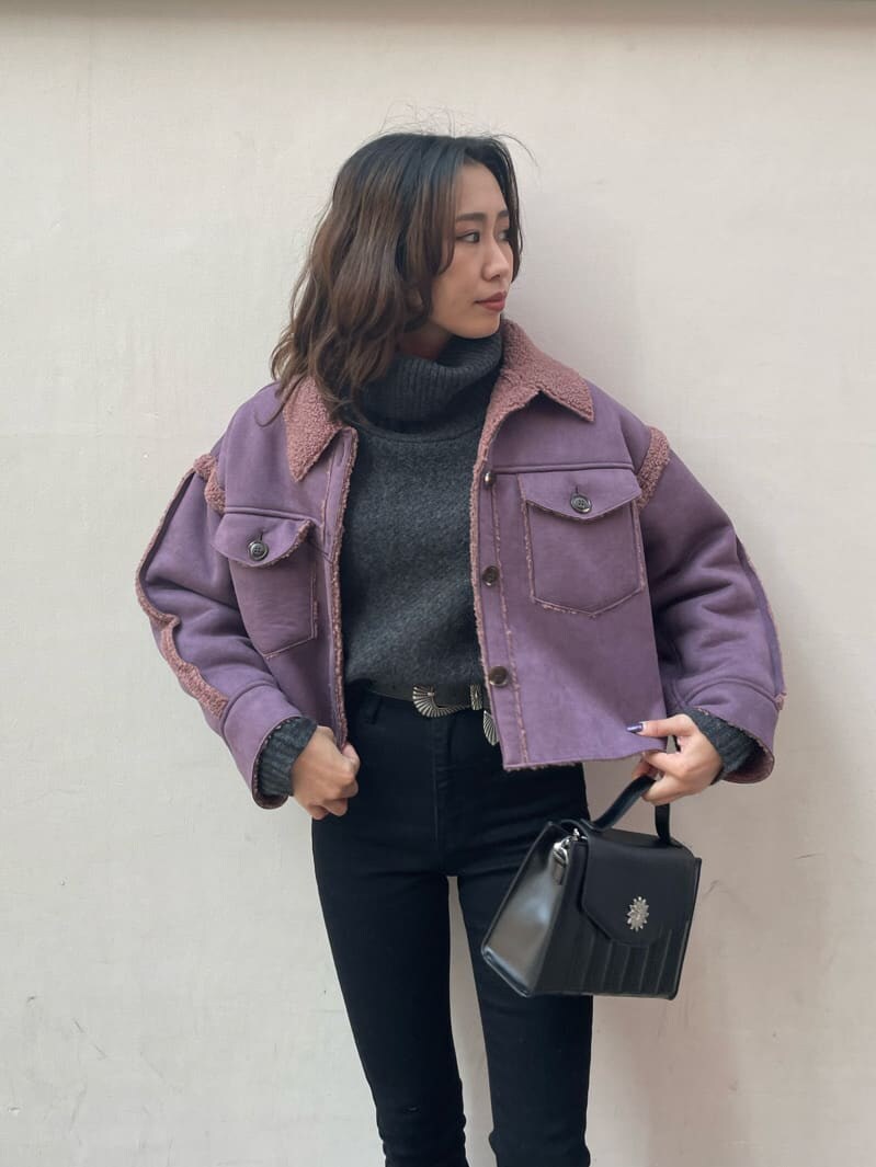 ブラック系のブーツ、パープル系のブルゾン、ブラック系のショルダーバッグを着用したレディースの冬コーディネートの3枚目の写真