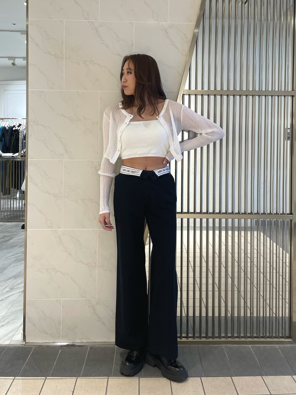 ブラック系のその他パンツ、ブラック系のブーツ、ホワイト系のカーディガン/ボレロを着用したレディースの春コーディネートの2枚目の写真