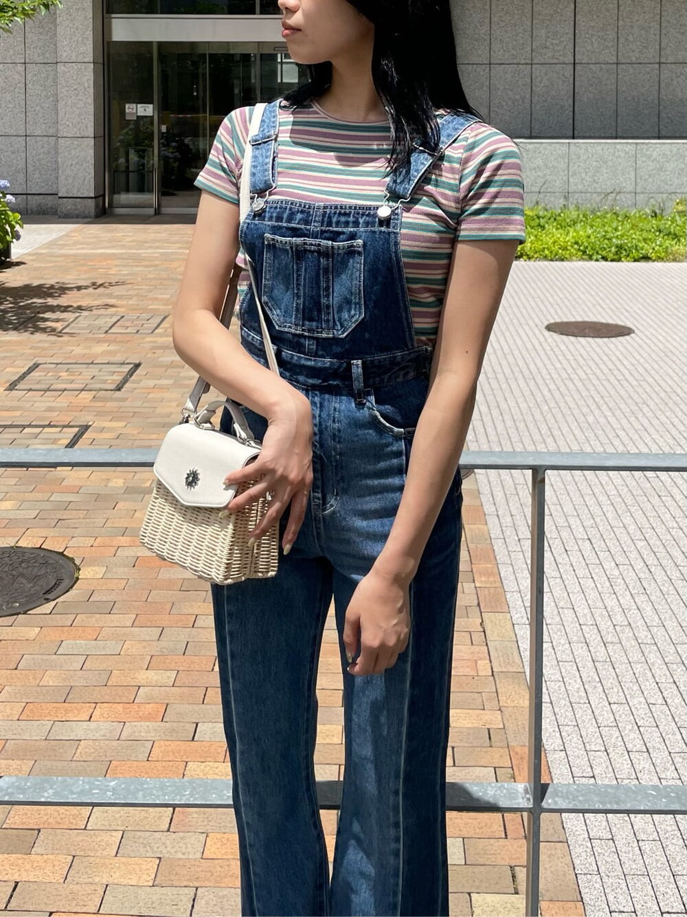 ブルー系のサロペット/オーバーオール、ホワイト系のサンダル、グリーン系のTシャツ/カットソーを着用したレディースの夏コーディネートの3枚目の写真