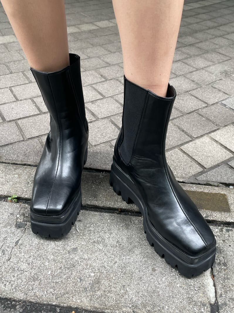 ホワイト系のつなぎ/オールインワン、ブラック系のブーツ、イエロー系のショルダーバッグを着用したレディースの春コーディネートの7枚目の写真