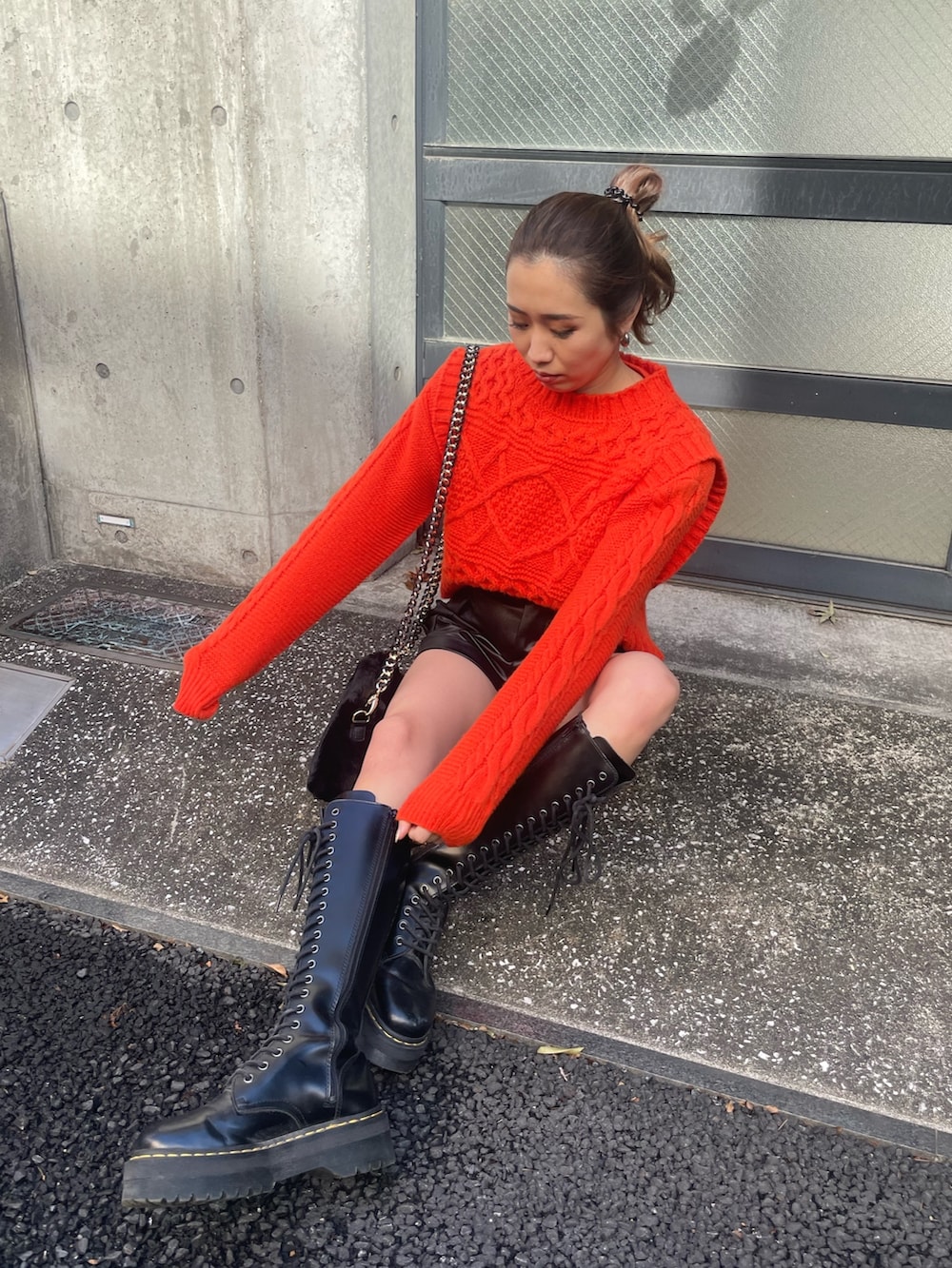 オレンジ系のニット/セーター、ブラック系のその他パンツ、ブラック系のショルダーバッグを着用したレディースの冬コーディネートの3枚目の写真