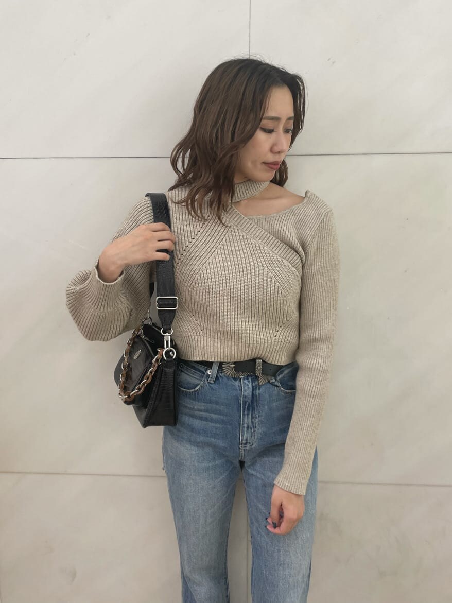 ブルー系のデニムパンツ、ホワイト系のニット/セーター、ブラック系のベルトを着用したレディースの秋コーディネートの5枚目の写真