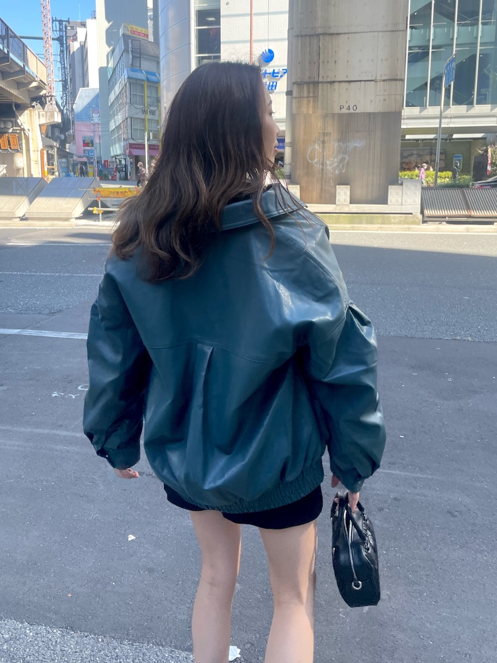 ホワイト系のショルダーバッグ、ブラック系のスカート、ブラック系のTシャツ/カットソーを着用したレディースの秋コーディネートの4枚目の写真