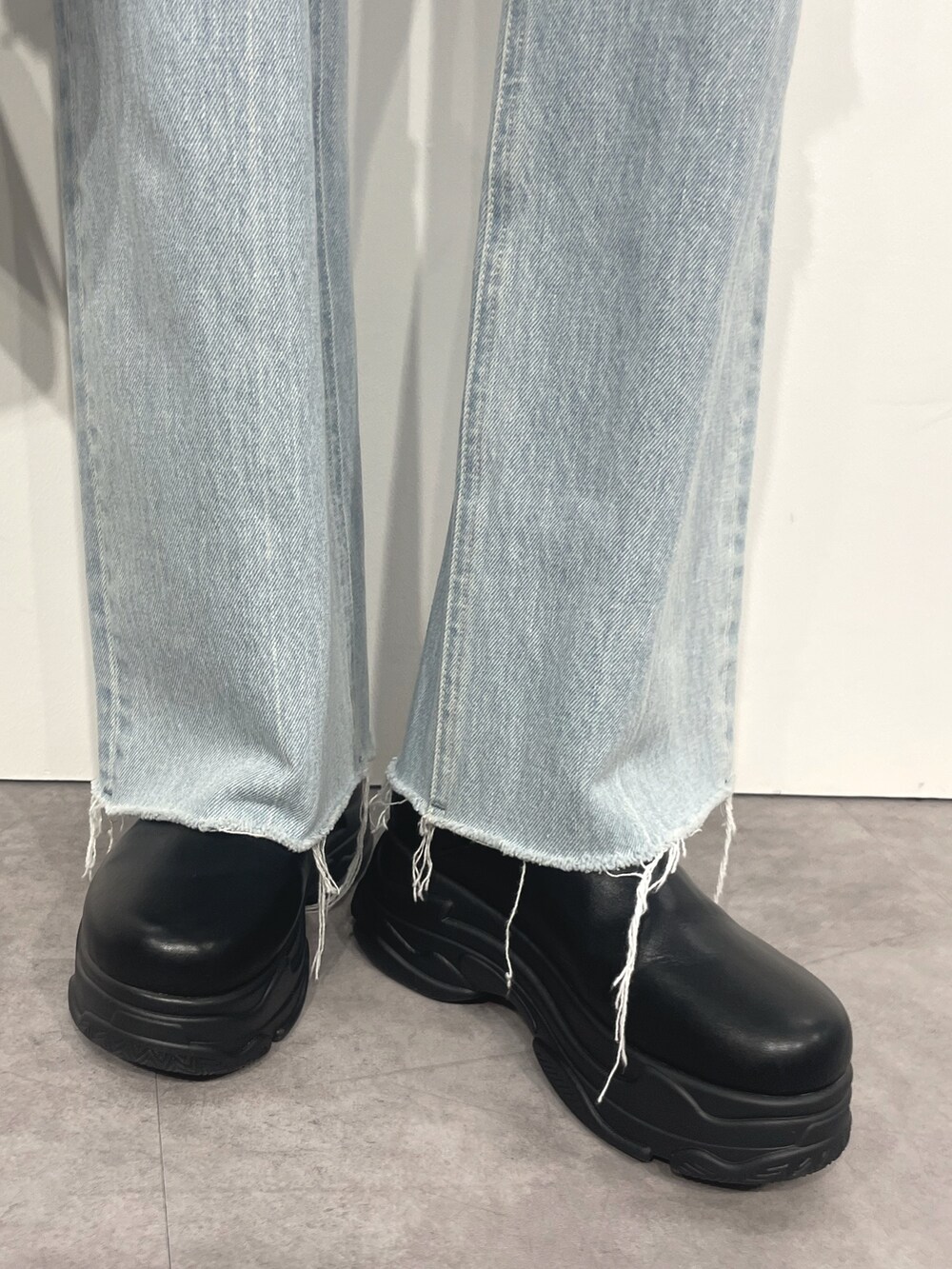 ブルー系のデニムパンツ、ブラック系のショルダーバッグ、ホワイト系のTシャツ/カットソーを着用したレディースの秋コーディネートの7枚目の写真