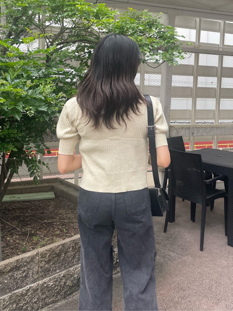 ブラック系のデニムパンツ、ブラック系のキャミソール、ホワイト系のカーディガン/ボレロを着用したレディースの春コーディネートの4枚目の写真