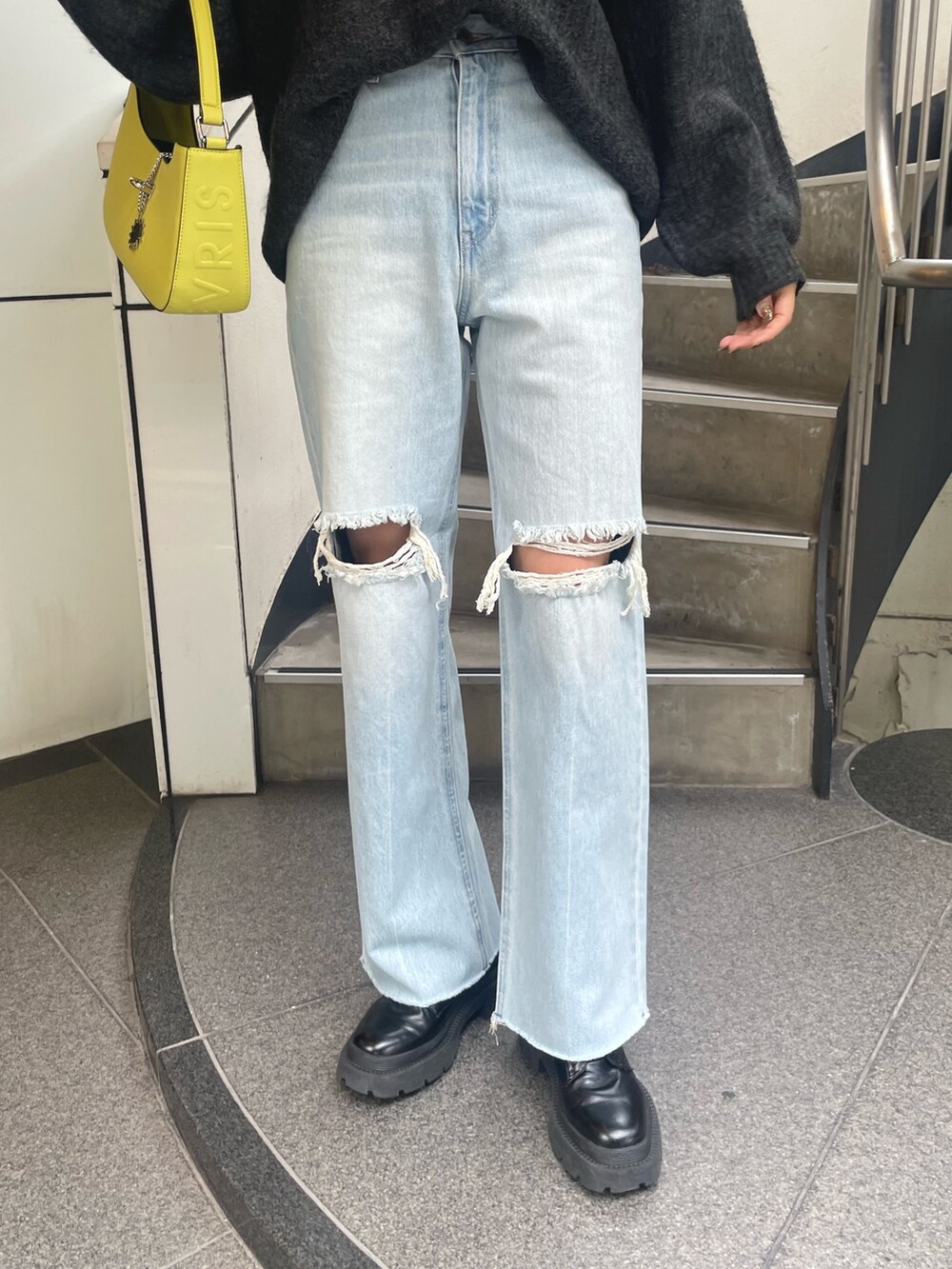 グレー系のニット/セーター、イエロー系のハンドバッグ、ブルー系のデニムパンツを着用したレディースの秋コーディネートの8枚目の写真