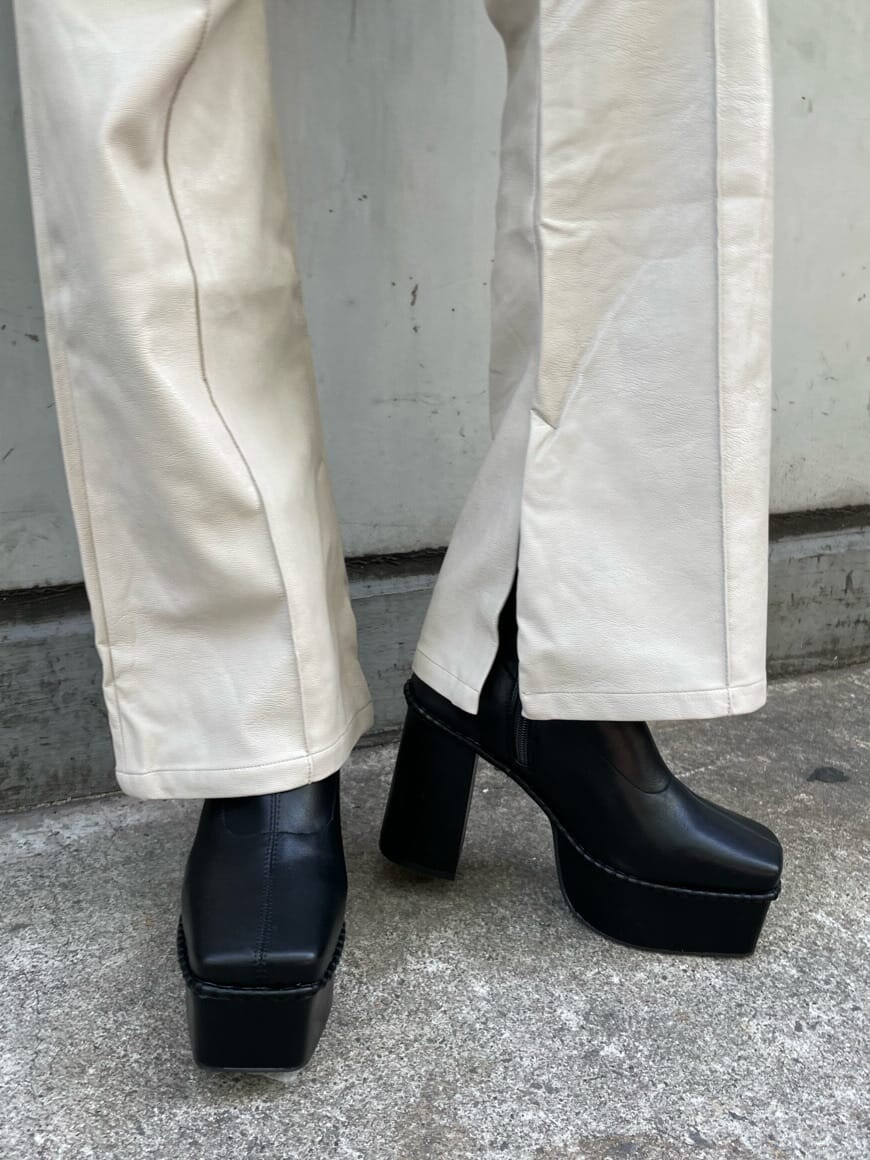 ブラック系のブーツ、パープル系のニット/セーター、ブラック系のショルダーバッグを着用したレディースの冬コーディネートの7枚目の写真