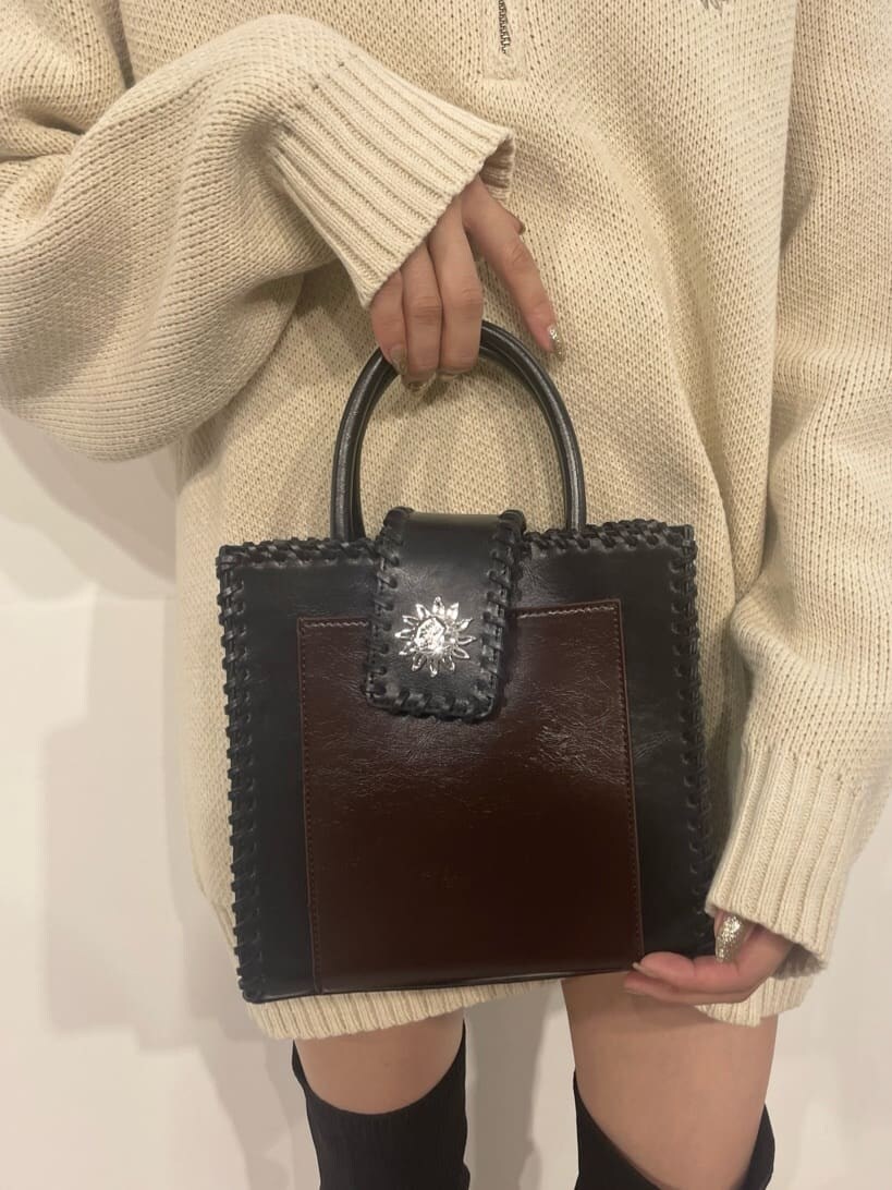 ブラック系のショルダーバッグ、ホワイト系のニット/セーター、ブラック系のブーツを着用したレディースの秋コーディネートの6枚目の写真