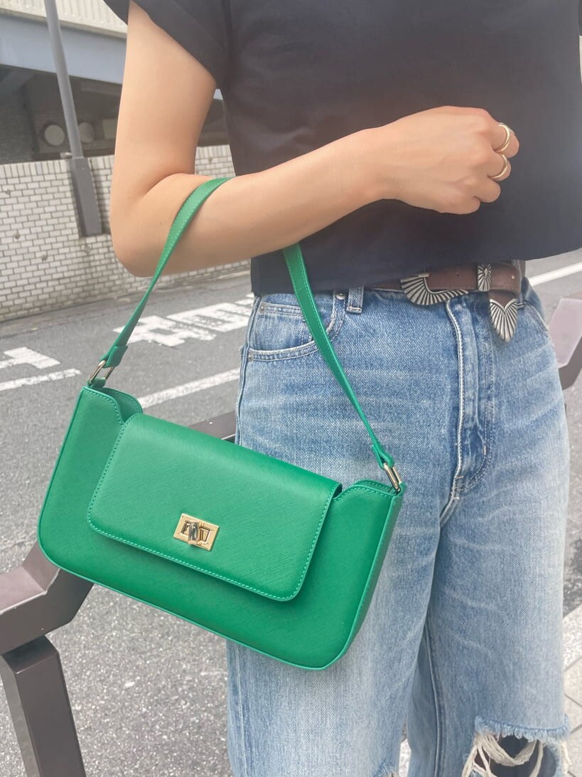 グリーン系のショルダーバッグ、ブルー系のデニムパンツ、ブラック系のスニーカーを着用したレディースの夏コーディネートの6枚目の写真