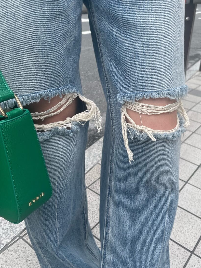 グリーン系のショルダーバッグ、ブルー系のデニムパンツ、ブラック系のスニーカーを着用したレディースの夏コーディネートの8枚目の写真